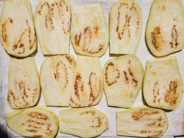 Baked Eggplant Parmesan Process Step 3a Salted eggplant slices sit on a few layers of paper towels to sweat.