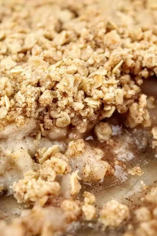 Vegan Gluten-Free Apple Crisp Process Step 4 A close up head on photo of the vegan gluten-free apple crisp right after it comes out of the oven. A few scoops have been removed, to clearly show the two layers: filling and topping.